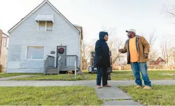  ?? ?? Property owner Justine Mosley Stephens, left, and homeowner Parker talk Dec. 11 on the 6500 block of South Aberdeen Street, where he lives. Parker is employed to do landscapin­g and snow removal work.