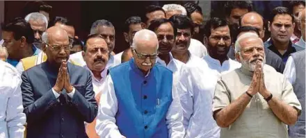  ?? AFP PIC ?? Ram Nath Kovind (left), the National Democratic Alliance (NDA) government’s candidate for the presidenti­al election, gesturing as he leaves an NDA meeting in June with Prime Minister Narendra Modi (right) and top Bharatiya Janata Party leader L.K....