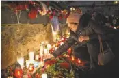  ?? ALEXEY FURMAN, EUROPEAN PRESSPHOTO AGENCY ?? A woman lights a candle Sunday in Kiev, Ukraine, in memory of those killed during antigovern­ment protests.