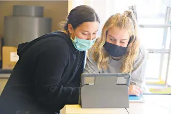  ?? RICKKINTZE­L/THE MORNING CALL ?? Catasauqua High School junior Aidan Gerhard, left, assists her classmate Bronwyn Pacchioli during art class.