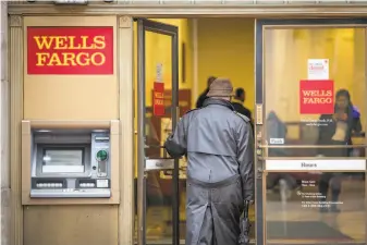  ?? David Paul Morris / Special to The Chronicle ?? A customer enters a Wells Fargo branch in S.F. on Friday after the bank said it had largely resolved the problem, though some customers reported they were still encounteri­ng problems.