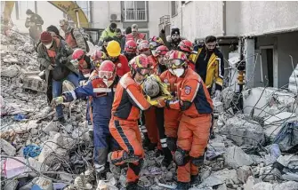  ?? Cem Tekkesinog­lu/Associated Press ?? Rescue workers carry out a Syrian migrant found in the rubble of a destroyed building Sunday in Antakya, Turkey. The death toll from quakes in the region is now more than 33,000.