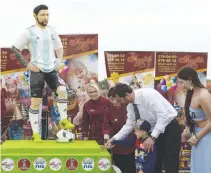  ??  ?? MAYOR of Bronnitsy Viktor Nevolin and a boy cut a birthday cake including a statue depicting Lionel Messi during a party organized by the town of Bronnitsy, where the Argentina football team have their base camp, near Moscow, on June 24, to celebrate...