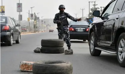  ?? Photograph: Pius Utomi Ekpei/AFP/Getty Images ?? An officer stops a car ahead of the 25 February presidenti­al election in Anambra state, Nigeria.