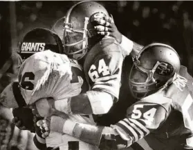  ?? Frederic Larson / The Chronicle 1981 ?? Niners defenders Jack Reynolds and Craig Puki tie up New York Giants running back Rob Carpenter during the 49ers’ 17-10 win on Nov. 29, 1981. The 49ers enjoyed a near 2-to-1 edge in time of possession (38:16 to 21:44).