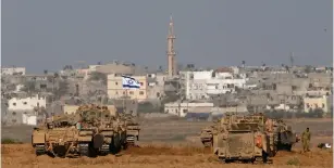  ?? (Baz Ratner/Reuters) ?? ISRAELI APCS outside Gaza during 2014’s Operation Protective Edge. Avi Dichter said Israel would not reconquer the Strip, but would spend an extended period there as it did in the West Bank during the Second Intifada.