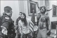  ?? MANUEL BALCE CENETA/AP ?? SUPPORTERS OF PRESIDENT DONALD TRUMP, including Jacob Chansley, right with fur hat, are confronted by U.S. Capitol Police officers outside the Senate chamber inside the Capitol during the capitol riot in Washington Jan. 6.