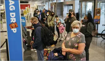  ?? TONY DEJAK — THE ASSOCIATED PRESS ?? Vickie Lechuk, right, waits in line to check baggage at Cleveland Hopkins Internatio­nal Airport, Wednesday, Nov. 25, in Cleveland. Lecuk is traveling to Tampa, Florida.