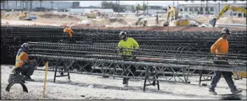  ?? Erik Verduzco Las Vegas Review-Journal ?? Workers handle steel rods March 6 at the future Raiders stadium site in Las Vegas. A Clark County official says pledged revenues are sufficient to secure the upcoming bonds to build the facility.