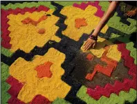  ?? ?? A sawdust rug is created Monday as an offering outside a church in preparatio­n for the arrival of the cross.