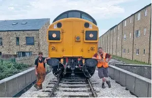  ?? PAUL GARNETT ?? Job done! Joe and James admire their handiwork with Class 37 No. 37075, which became the first locomotive to pass over Bridge 11 after it was handed over to the ‘Ops’ department on July 31.