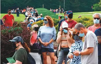  ?? AFP ?? Voters wait in line to cast their ballots at an early voting location in Fairfax, Virginia. The US Elections Project, run by the University of Florida, yesterday said that more than 35 million Americans have now voted by mail and more than 15 million in person.