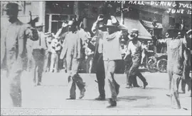  ?? Tulsa Historical Society / Associated Press ?? BLACK RESIDENTS are detained on June 1, 1921, in an explosion of violence perpetrate­d by white mobs that is known as the Tulsa Race Massacre.