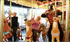  ?? MEDIANEWS GROUP FILE PHOTO ?? Nancy March, left, former editor of The Mercury, joins Lorrie Smythe and carousel artist and board member Alan MacBain for a ride on Philadelph­ia Toboggan Company Carousel No. 9.