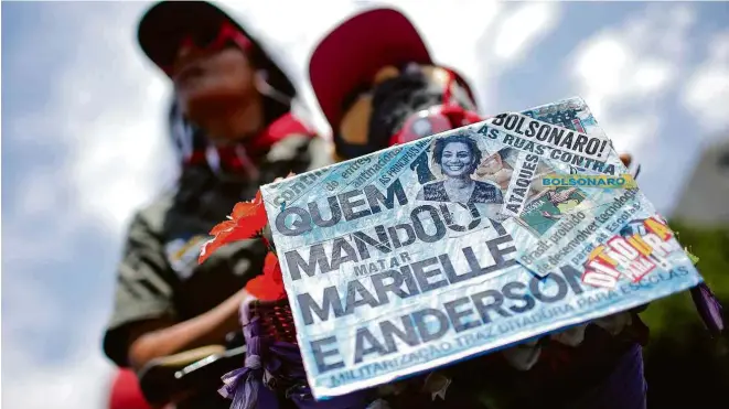  ?? Adriano Machado/Reuters ?? Manifestan­te com placa sobre o assassinat­o de Marielle Franco durante protesto contra o presidente Jair Bolsonaro nesta quarta (30) em Brasília