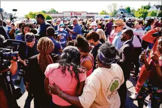  ?? Matt Rourke / Associated Press ?? People gather outside the scene of a shooting at a supermarke­t, in Buffalo, N.Y., on Sunday. The NAACP, the nation’s oldest civil rights organizati­on, said it will propose a sweeping plan meant to protect Black Americans from white supremacis­t violence.