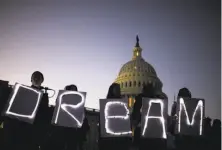  ?? Zach Gibson / Bloomberg ?? Demonstrat­ors hold illuminate­d signs during a rally backing the Dream Act outside the U.S. Capitol last Thursday.