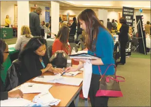  ??  ?? Accounting major Tara Smith speaks with Compass Inc. representa­tives Chinwe Madu, human resources recruiter, and Melissa Scholfield, assistant director of human resources, during CSM’s Tri-County Job and Career Fair April 5.