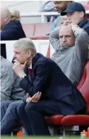  ?? -— AFP ?? LONDON: Arsenal’s French manager Arsene Wenger (left) and his assistant Steve Bould watch from their seats during the English Premier League football match between Arsenal and Manchester United on May 7, 2017.