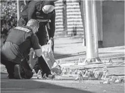  ?? JERRY JACKSON/BALTIMORE SUN ?? Baltimore Police forensics technician­s bag evidence at the shooting scene in the 700 block of North Rose Street where a gunman fired more than 60 rounds with an assault weapon Tuesday. Police said one person was killed.