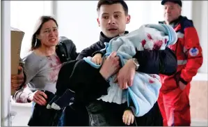  ?? ?? DESPERATE: Marina Yatsko and Fedor rush into the hospital, carrying their injured son