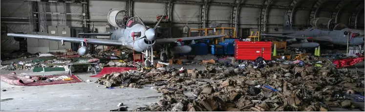 ?? Photo: Nampa/AFP ?? Grip… Afghan Air Force’s A-29 attack aircrafts are pictured as armoured vests are lying on the ground inside a hangar at the airport in Kabul.