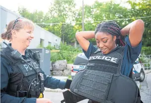  ?? JUSTIN GREAVES TORSTAR ?? Sgt. Joanne Venn helps Aaliyah Wright, a student enrolled in the Youth In Policing Initiative program, put on a ballistics vest at the Toronto Police Dog Services unit in East York.