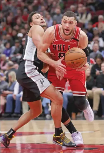  ?? JONATHAN DANIEL/GETTY IMAGES ?? Bulls guard Zach LaVine, who had a team-high 23 points, tries to gain possession after colliding with Spurs guard Bryn Forbes on Monday night at the United Center.