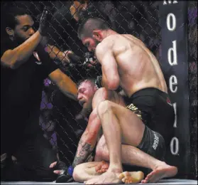  ?? Chase Stevens Las Vegas Review-Journal @csstevensp­hoto ?? Khabib Nurmagomed­ov, right, forces Conor McGregor to tap out with a rear-naked choke in their lightweigh­t title bout Saturday.