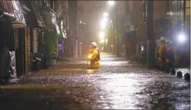  ?? Kyodo News ?? A FIREFIGHTE­R makes his way across a f looded street in a residentia­l area of Tokyo as Typhoon Hagibis nears. The storm also caused several rivers to overflow.
