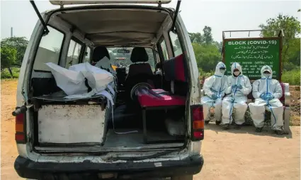  ?? EFE ?? Sanitarios indios con EPIS tras recoger el cadáver de un fallecido por la Covid-19