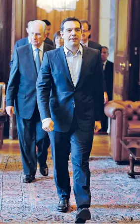  ??  ?? Il premier greco Alexis Tsipras arriva al Palazzo presidenzi­ale con il presidente uscente Karolos Papoulias, dietro di lui nella foto