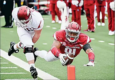  ?? Jason Sterling/Special to News-Times ?? Head first: Arkansas defensive lineman Michael Taylor II dives for the end zone in Saturday's Red-White game at Little Rock's War Memorial Stadium. Taylor had picked up a fumble caused by Junction City's Jamario Bell.