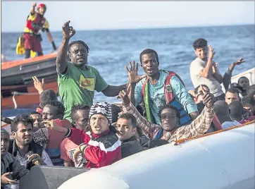  ?? OLMO CALVO — THE ASSOCIATED PRESS ?? Migrants aboard a rubber dinghy off the Libyan coast wave to rescuers aboard the Open Arms aid boat, of Proactiva Open Arms Spanish NGO, Saturday. Sixty migrants were rescued.