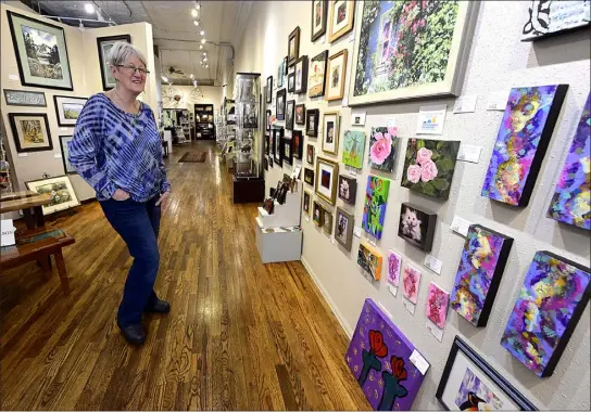  ?? ?? Loveland artist Billie Colson shows off some of the pieces on display Friday as part of the ‘65Roses for Cystic Fibrosis’ benefit exhibit at Independen­ce Gallery in downtown Loveland.