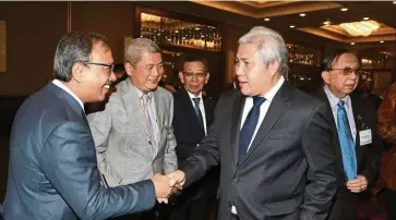  ??  ?? Big projects: Awang Tengah (second from right) greeting a participan­t at the event in Kuching. He says the funds for the three agencies are part of the Rm21.67bil state fund set aside for the implementa­tion of various mega infrastruc­ture projects.