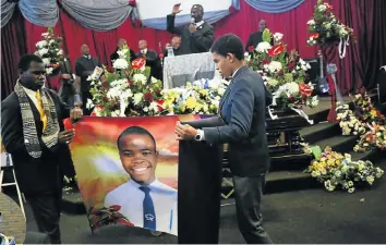  ?? Picture: Alaister Russell ?? Pupils hold a banner with the picture of Luyanda Tshabalala at his funeral in Ennerdale, south of Johannesbu­rg, yesterday. He was allegedly accidental­ly shot by his father, Sibusiso Emanuel Tshabalala, inset.