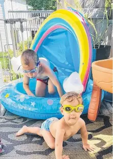  ??  ?? You don’t have to go very far to find some relief from the heat. Nicole Moore watched as two of her children, Taylor, fouryears-old and Everly, one, had a blast and a splash or two on their back deck in Timberlea.