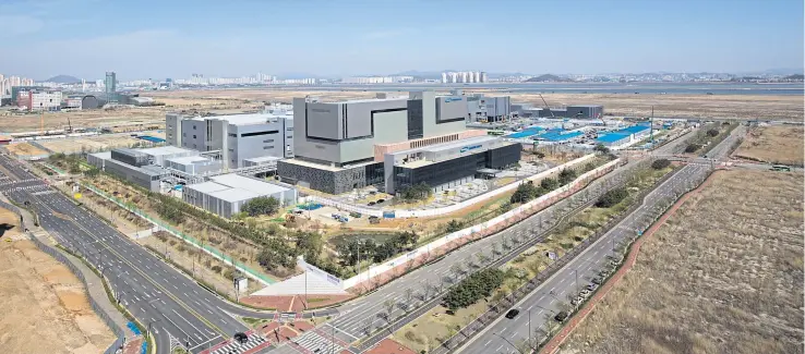  ?? PHOTOS BY BLOOMBERG ?? Plant 3, right, stands under constructi­on at the Samsung BioLogics Co Ltd’s headquarte­rs and production facilities in Songdo district in Incheon, South Korea.