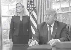  ??  ?? President Donald Trump listens as Homeland Security Secretary Kirstjen Nielsen speaks about administra­tion policy Wednesday. PABLO MARTINEZ MONSIVAIS/AP