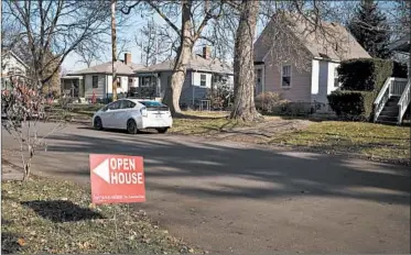  ?? TY WRIGHT/BLOOMBERG NEWS/2017 ?? An "Open House" sign is displayed in the front yard of a home for sale in Columbus, Ohio, U.S., on Dec. 3, 2017. Home equity accounts for 54 percent of all the welath held by black households in the United States.