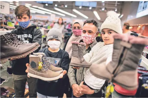  ?? FOTO: RALPH MATZERATH ?? Auch die drei Kinder der Familie Mohamad durften sich ein Paar Schuhe aussuchen.