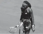  ?? Clive Brunskill / Getty Images ?? Coco Gauff carries her broken racket during her quarterfin­al loss to Barbora Krejcikova.