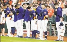  ?? Michael Wyke / Associated Press ?? Houston Astros players bow their heads during a moment of silence in remembranc­e of the the mass shooting victims in El Paso, Texas.