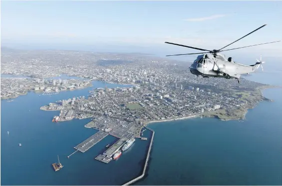  ??  ?? A Sea King flies over Victoria, with Ogden Point in the foreground. After 55 years, the helicopter’s service to Canada is coming to an end. On Saturday, the Royal Canadian Air Force held a flypast ceremony honouring the aircraft. It will be replaced by the CH-148 Cyclone, two of which have already arrived at Patricia Bay.