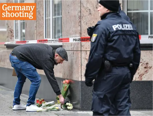  ?? Photo: AP ?? A man places flowers near a hookah bar where several people were killed on Wednesday night in Hanau, Germany, yesterday. A 43-year-old German man shot and killed several people at more than one location in a Frankfurt suburb overnight, in attacks that appear to have been motivated by far-right beliefs, officials said.