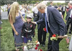  ?? EVAN VUCCI / AP ?? Brittany Jacobs (left) watches as her 6-year-old son Christian Jacobs talks with President Donald Trump Monday in Section 60 of Arlington National Cemetery in Virginia. Christian’s father, Marine Sgt. Christophe­r Jacobs, was killed in 2011.