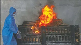  ?? (AP/Rafiq Maqbool) ?? A municipal worker in personal protective suit does last rites during the cremation of a covid-19 victim in Vasai, on the outskirts of Mumbai, India.