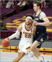  ?? JIM MONE — THE ASSOCIATED PRESS ?? Minnesota’s Gabe Kalscheur, left, drives around Michigan’s Franz Wagner during Saturday’s game. The Wolverines lost for the first this season, 75-57, and are now 11-1overall, 6-1in the Big Ten.