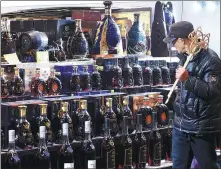  ?? PROVIDED TO CHINA DAILY ?? Left: A customer walks past an array of imported alcoholic products at a supermarke­t in Hangzhou, capital of Zhejiang province. WANG GANG / CHINA NEWS SERVICE Right: Consumers queue up for payments at a duty-free store in Beijing.